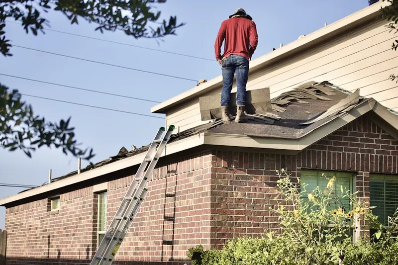 Professional roofer working on a residential roof in Mission Manor